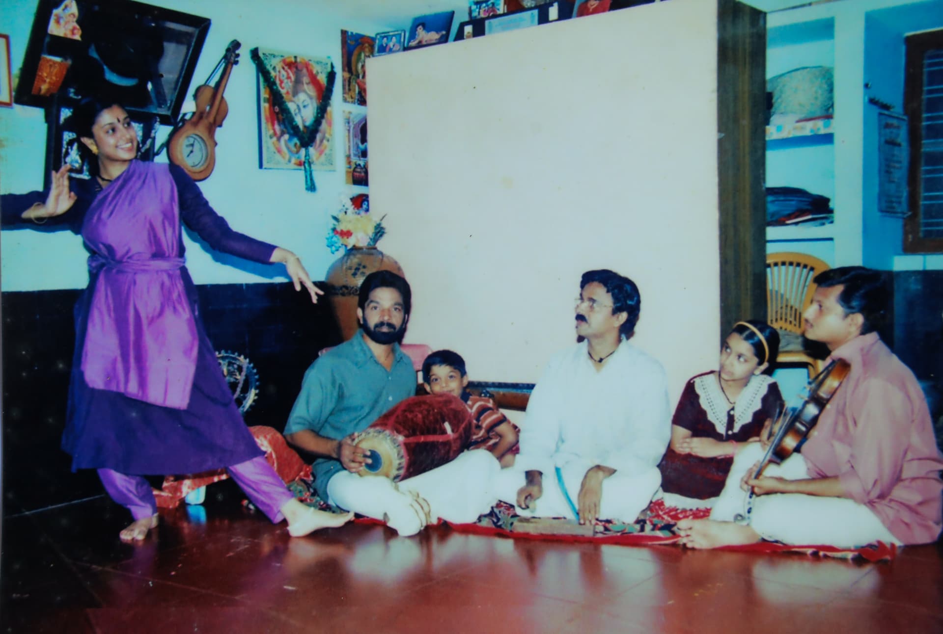 A young dancer performing while the family accompanies her on mridangam, vocals and violin